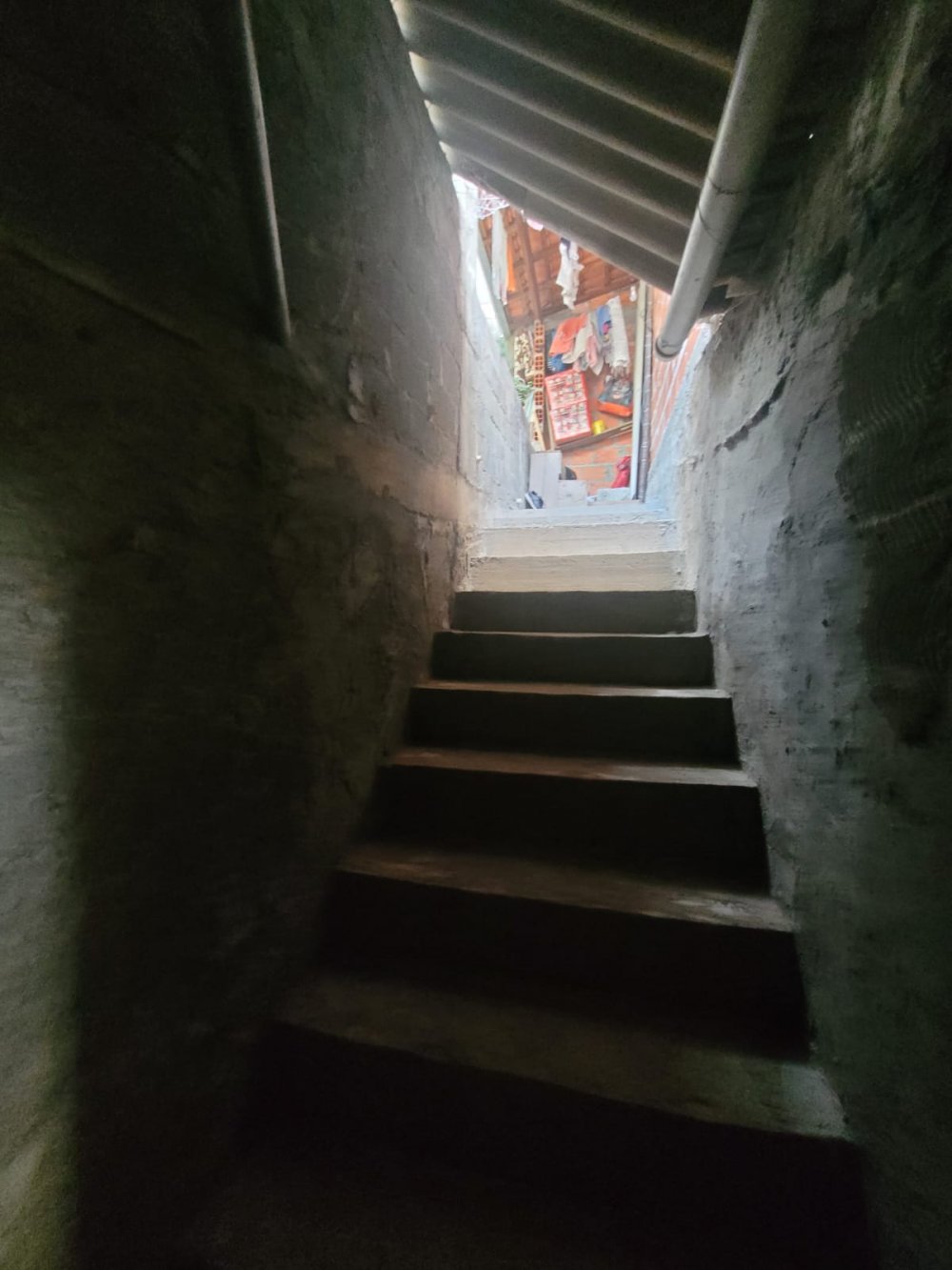 Escada que dá acesso ao piso superior e lote nos fundos